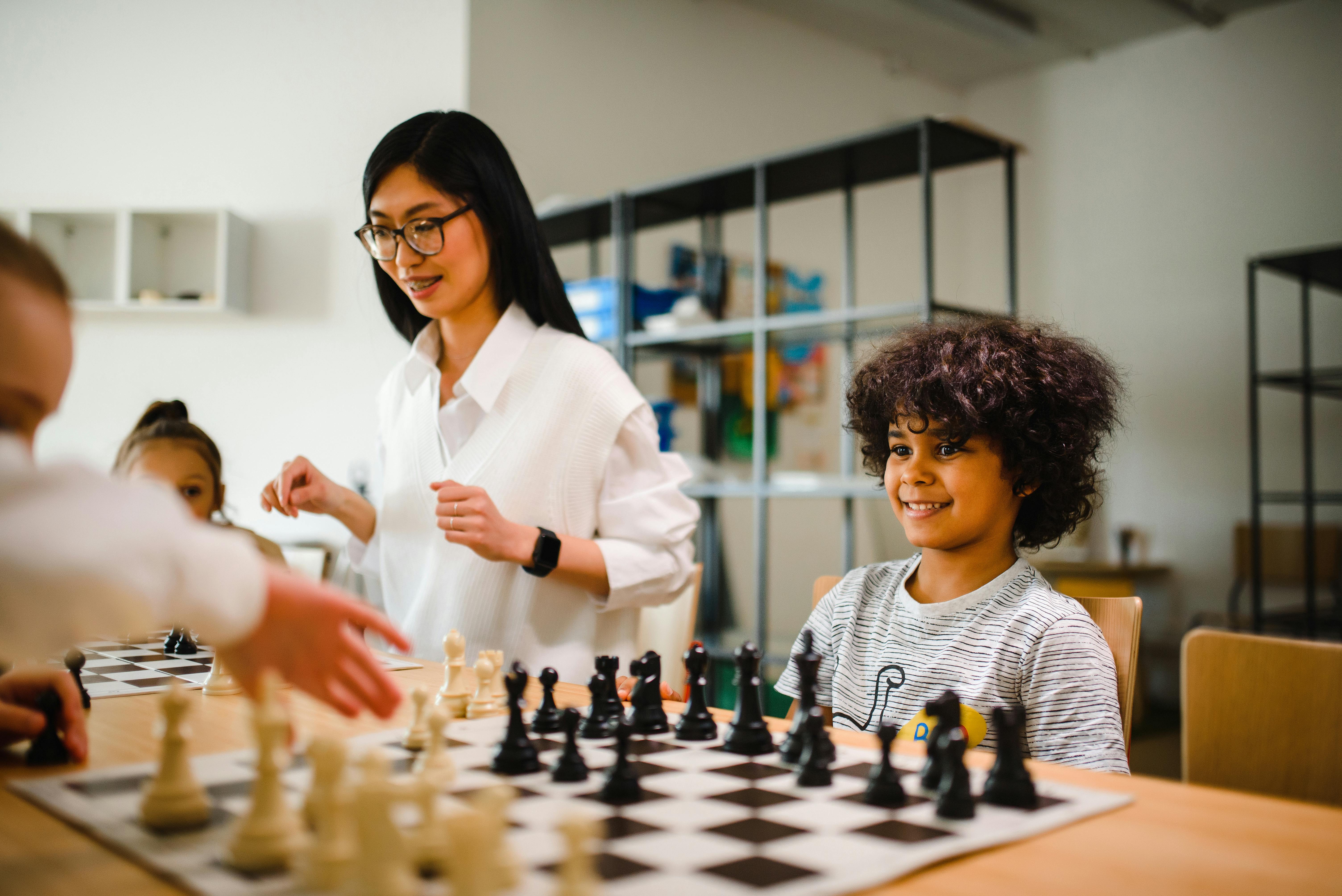 Club in Action 1, children palying chess and a teacher